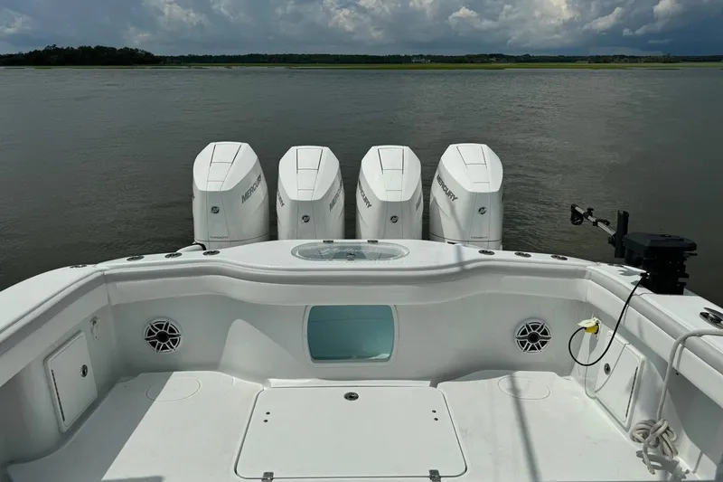 Slide: The Image of 2024 Yellowfin 39 Offshore boat with four Mercury outboard engines on a calm water backdrop. - 4