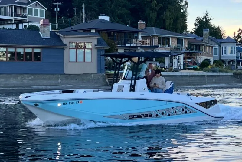 Slide: The Image of 2018 Scarab 255 Open ID boat cruising near waterfront homes. - 3