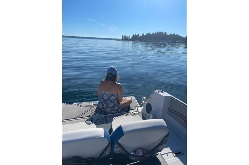 Slide: The Image of Woman relaxing on a 2018 Scarab 255 Open ID boat, enjoying serene lake views. - 9