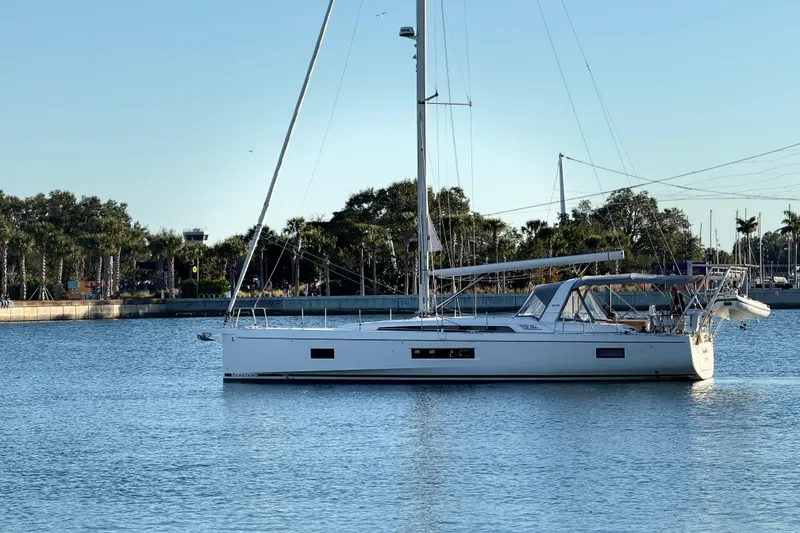 Slide: The Image of 2020 Beneteau Oceanis 51.1 sailboat anchored in calm waters near a marina. - 57