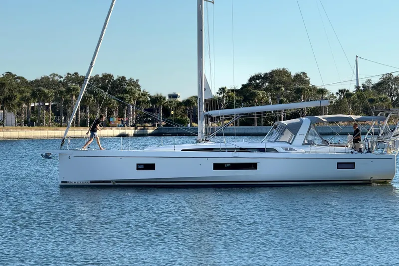 Slide: The Image of 2020 Beneteau Oceanis 51.1 sailboat on calm water, with people on deck. - 58