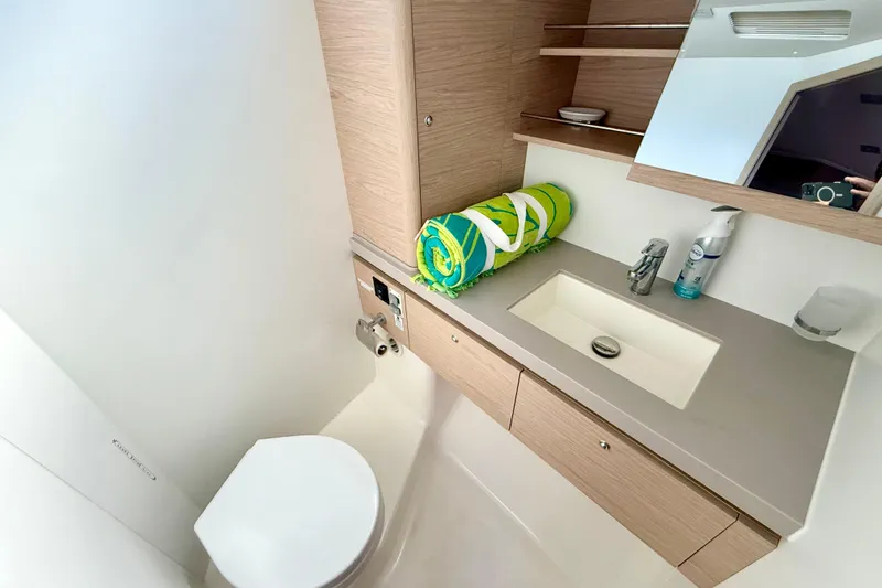 Slide: The Image of Modern bathroom in 2020 Beneteau Oceanis 51.1 yacht with sink, toilet, and storage. - 67