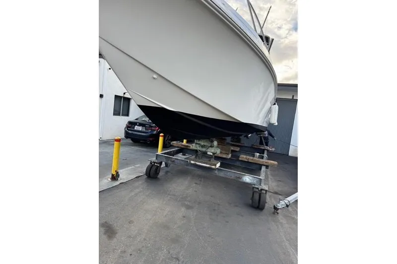 Slide: The Image of 2004 Fountain 31 Tournament Edition boat on trailer in a parking area. - 11