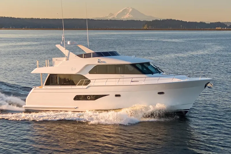 The Image of 2025 Apollonian Yachts 52 Pilothouse cruising on open water with mountain backdrop. - 0