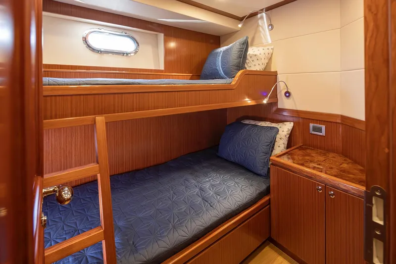 Slide: The Image of Luxurious 2025 Apollonian Yachts 52 Pilothouse cabin with wooden bunk beds and elegant decor. - 22