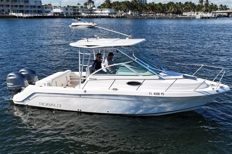 The Image of 2014 Robalo R265 Walkaround boat cruising on water with two passengers. - 0