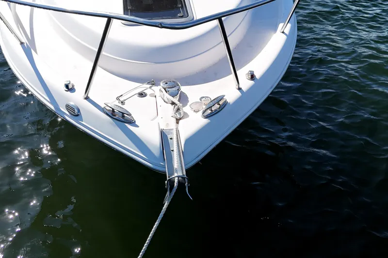 Slide: The Image of 2014 Robalo R265 Walkaround boat bow on water, featuring anchor and railing. - 11