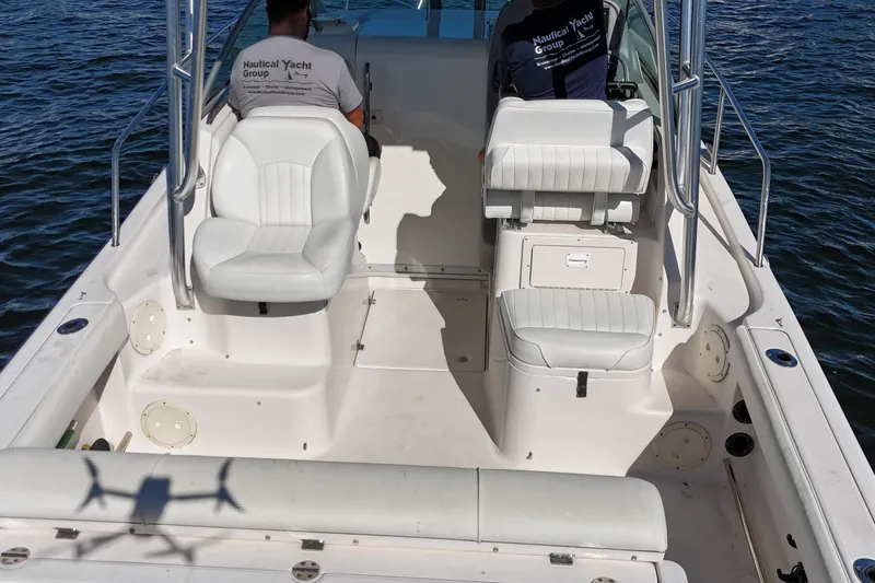 Slide: The Image of 2014 Robalo R265 Walkaround boat interior with white seating and two people onboard. - 15