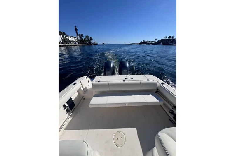 Slide: The Image of 2014 Robalo R265 Walkaround boat cruising on a sunny day, scenic waterfront view. - 19