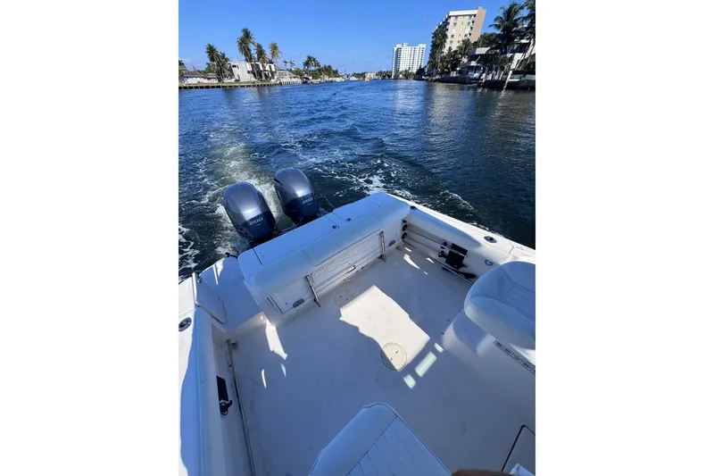 Slide: The Image of 2014 Robalo R265 Walkaround boat cruising on a scenic waterway with twin engines. - 20