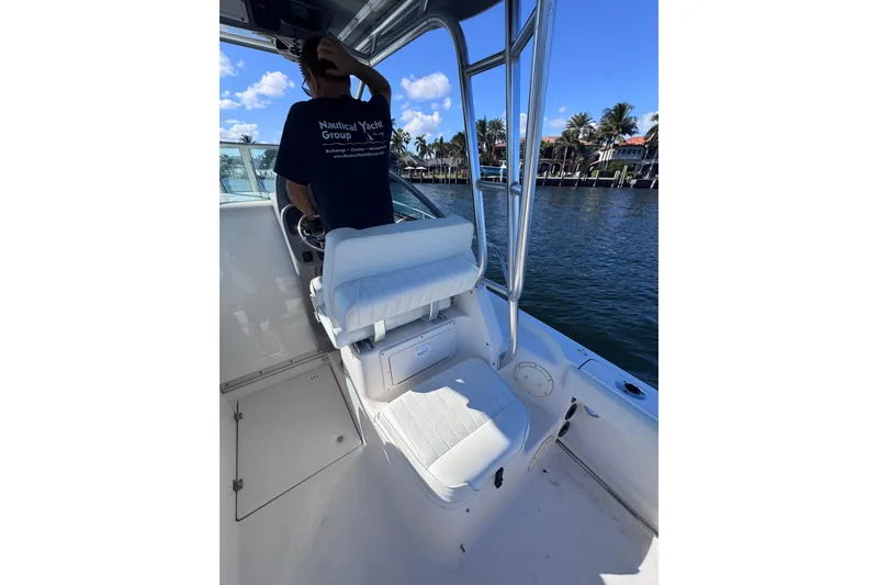 Slide: The Image of 2014 Robalo R265 Walkaround boat interior with seating and steering, cruising on a sunny day. - 23