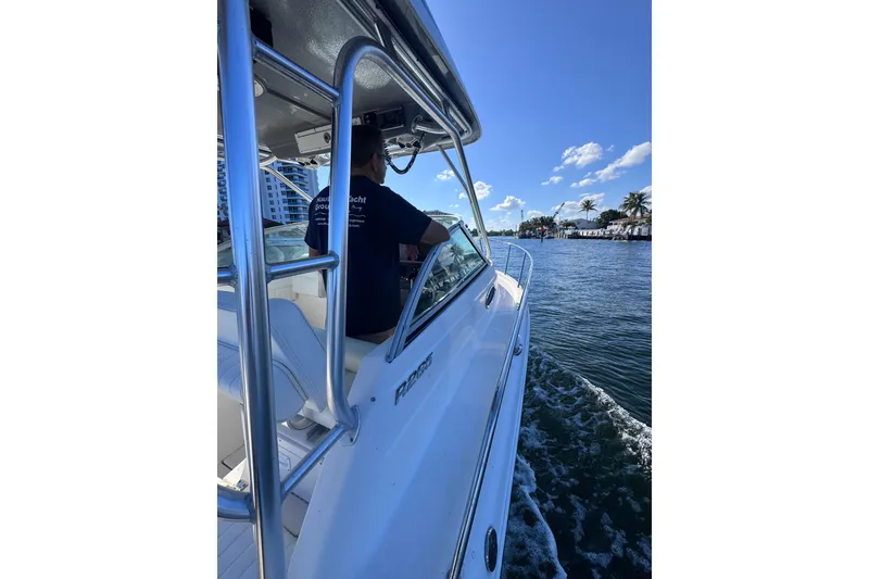 Slide: The Image of 2014 Robalo R265 Walkaround cruising on a sunny day with palm trees in the background. - 25