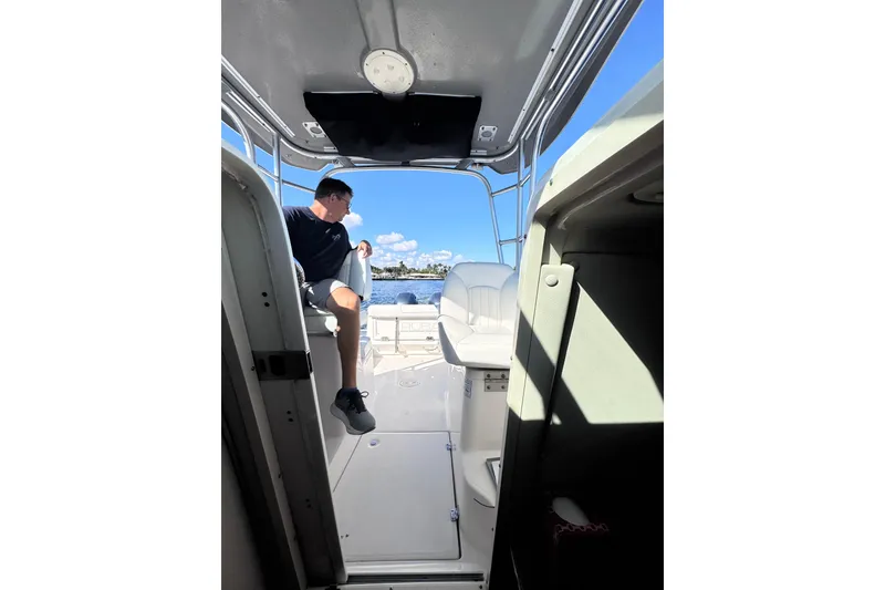 Slide: The Image of 2014 Robalo R265 Walkaround interior with person seated, overlooking water. - 38