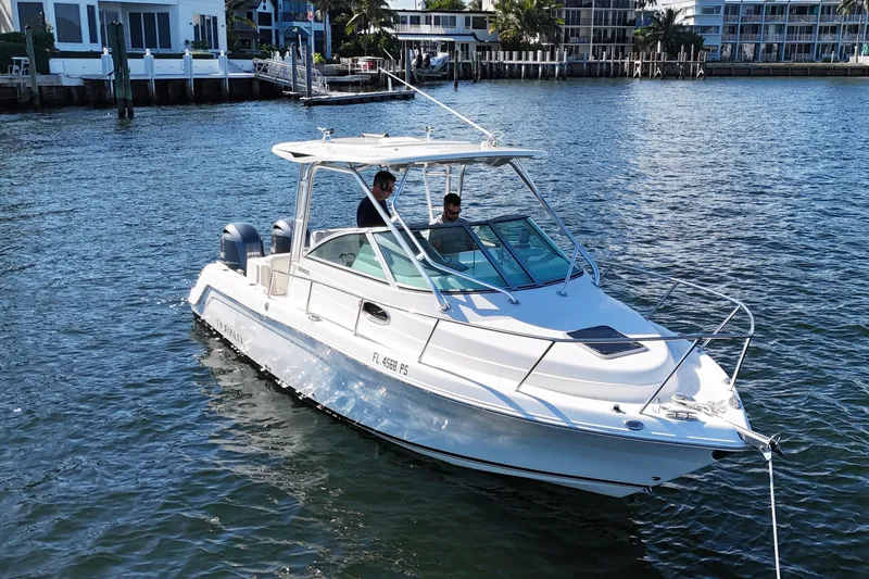 Slide: The Image of 2014 Robalo R265 Walkaround boat cruising on a sunny waterfront. - 4