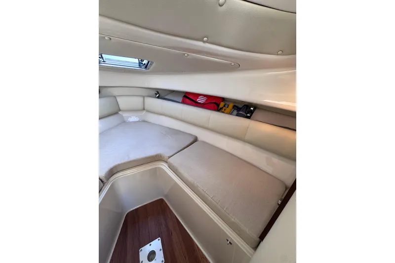 Slide: The Image of 2014 Robalo R265 Walkaround cabin interior with beige seating and storage. - 40