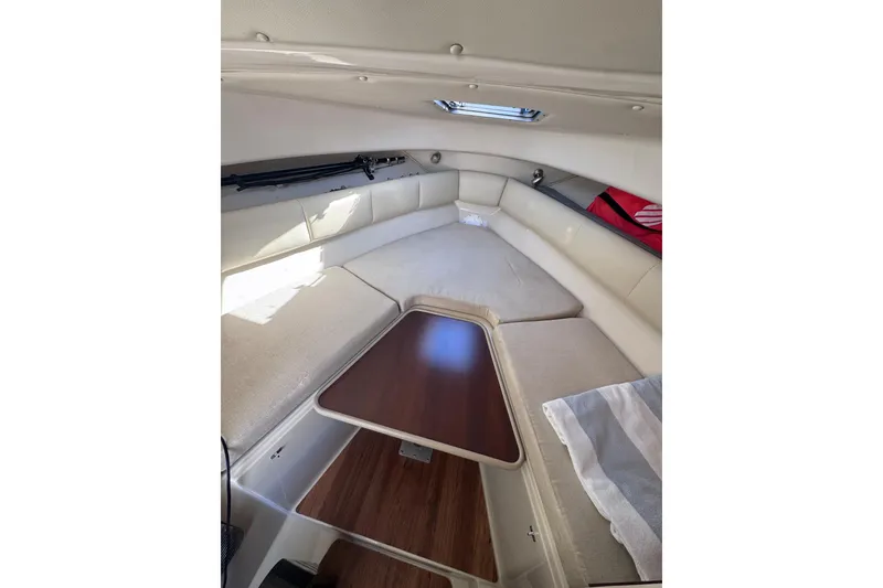 Slide: The Image of 2014 Robalo R265 Walkaround cabin interior with cushioned seating and wooden table. - 41
