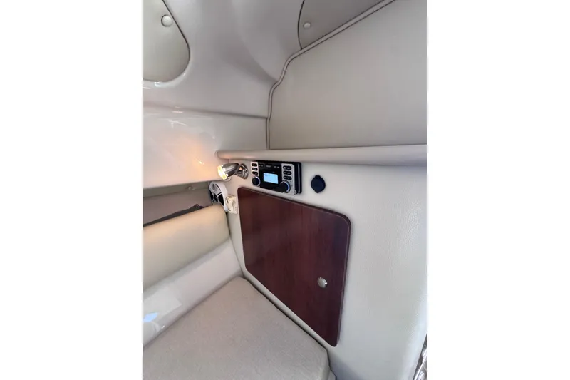 Slide: The Image of 2014 Robalo R265 Walkaround cabin interior with control panel and wooden cabinet. - 44