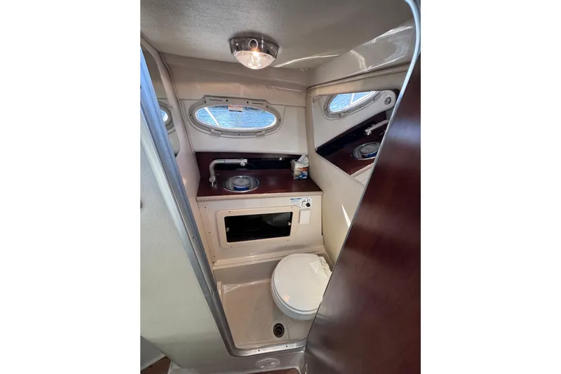 Slide: The Image of 2014 Robalo R265 Walkaround boat interior with compact bathroom and porthole window. - 45