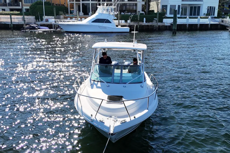 Slide: The Image of 2014 Robalo R265 Walkaround boat on sparkling water near waterfront homes. - 8