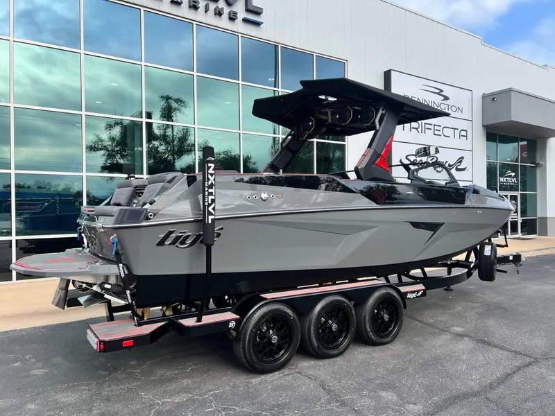Slide: The Image of 2026 Tigé 24RZX boat on trailer outside dealership, sleek gray design, modern features. - 3