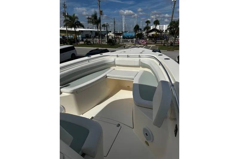 Slide: The Image of 2018 Cobia 301 Center Console boat with spacious seating, docked under a sunny sky. - 13