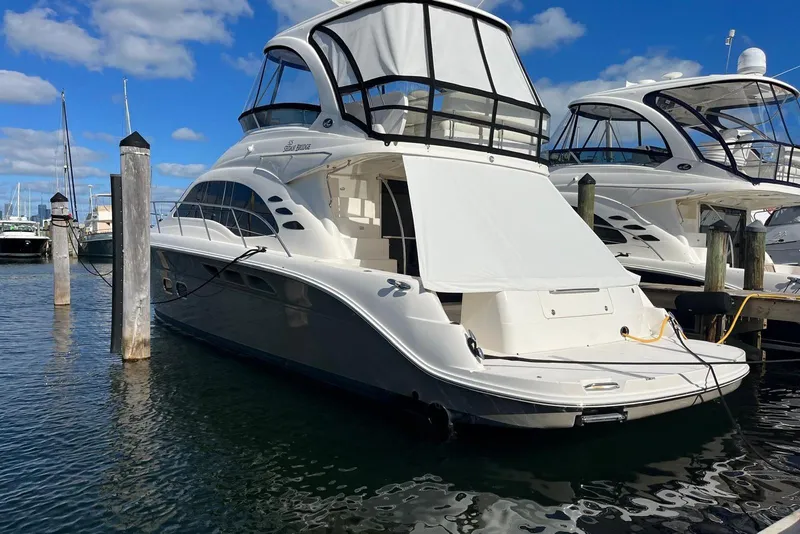 Slide: The Image of 2006 Sea Ray 52 Sedan Bridge yacht docked at marina under blue sky. - 10