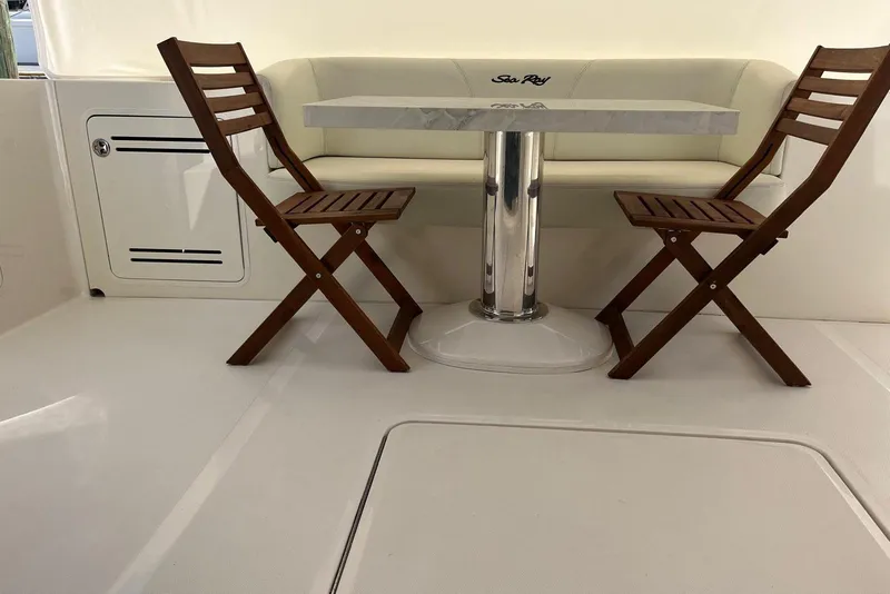 Slide: The Image of 2006 Sea Ray 52 Sedan Bridge interior with wooden chairs and a table. - 13