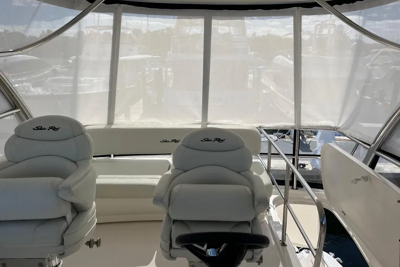 Slide: The Image of Interior of 2006 Sea Ray 52 Sedan Bridge with white seating and helm. - 25