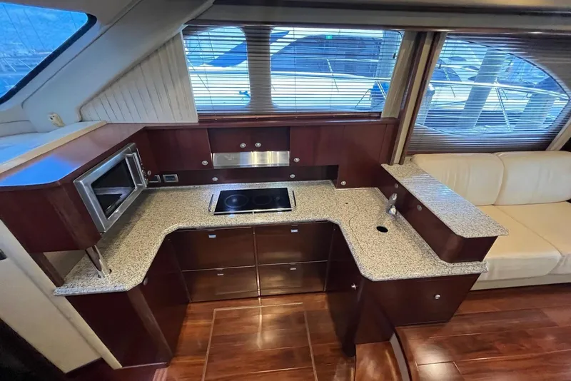 Slide: The Image of Luxurious 2006 Sea Ray 52 Sedan Bridge yacht kitchen with modern appliances and elegant wood finish. - 32