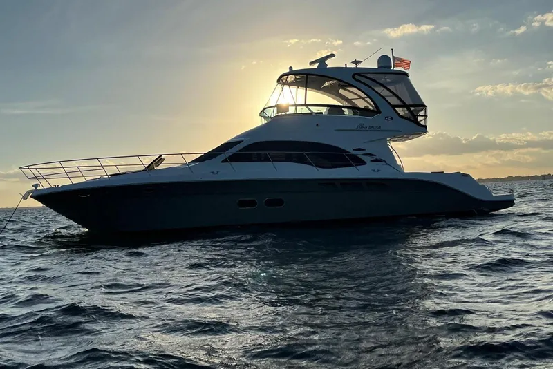 Slide: The Image of 2006 Sea Ray 52 Sedan Bridge yacht silhouetted against sunset on open water. - 4