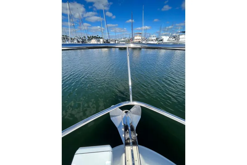Slide: The Image of Bow view of 2006 Sea Ray 52 Sedan Bridge in a marina, under blue skies. - 6