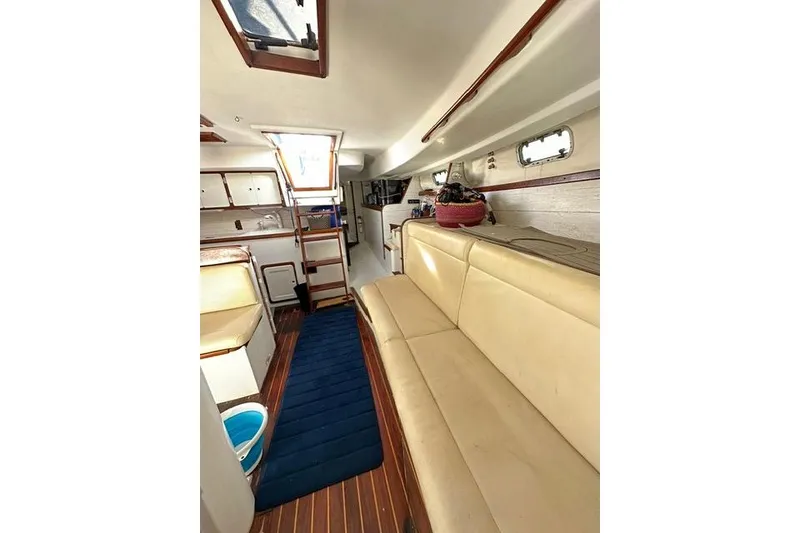 Slide: The Image of Interior of 1987 Morgan Classic 41 yacht, featuring beige seating and wooden flooring. - 4