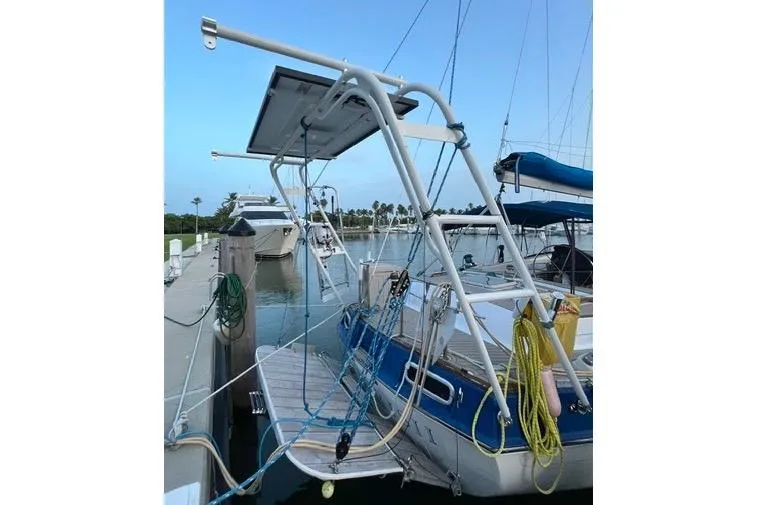 Slide: The Image of 1987 Morgan Classic 41 sailboat docked, featuring a solar panel and nautical equipment. - 6