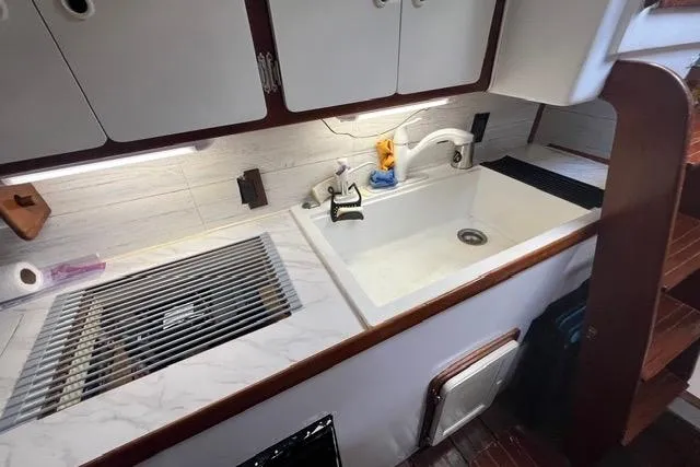 Slide: The Image of 1987 Morgan Classic 41 yacht kitchen with sink, cabinets, and wooden accents. - 9