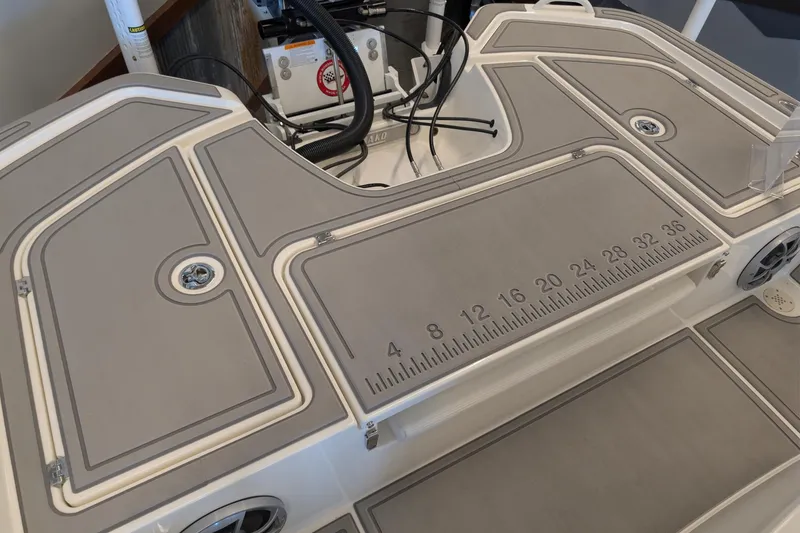 Slide: The Image of Deck of 2026 Mako 24 APEX boat with integrated ruler and storage compartments. - 12