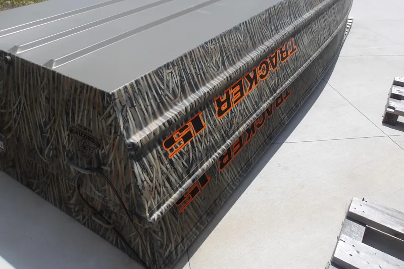 Slide: The Image of 2026 Tracker Grizzly 15 Jon boat with camouflage design on concrete surface. - 2