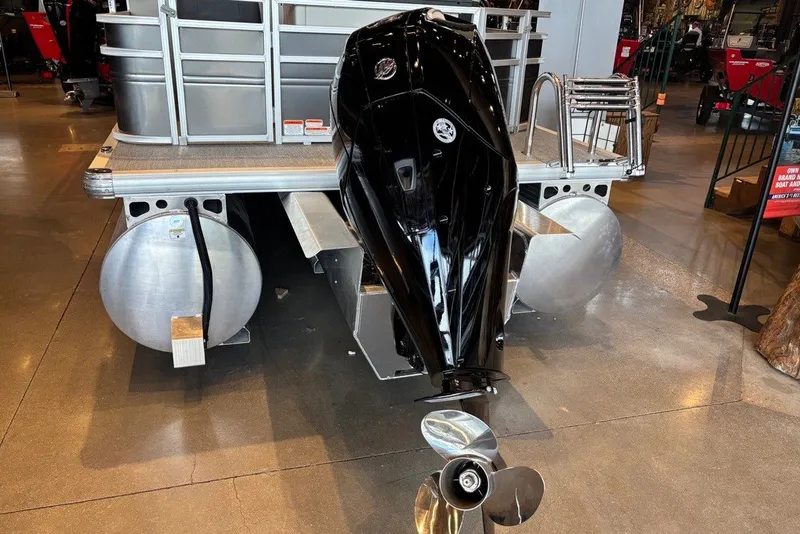 Slide: The Image of 2026 Sun Tracker Fishin' Barge 22 XP3 pontoon boat with outboard motor displayed indoors. - 13