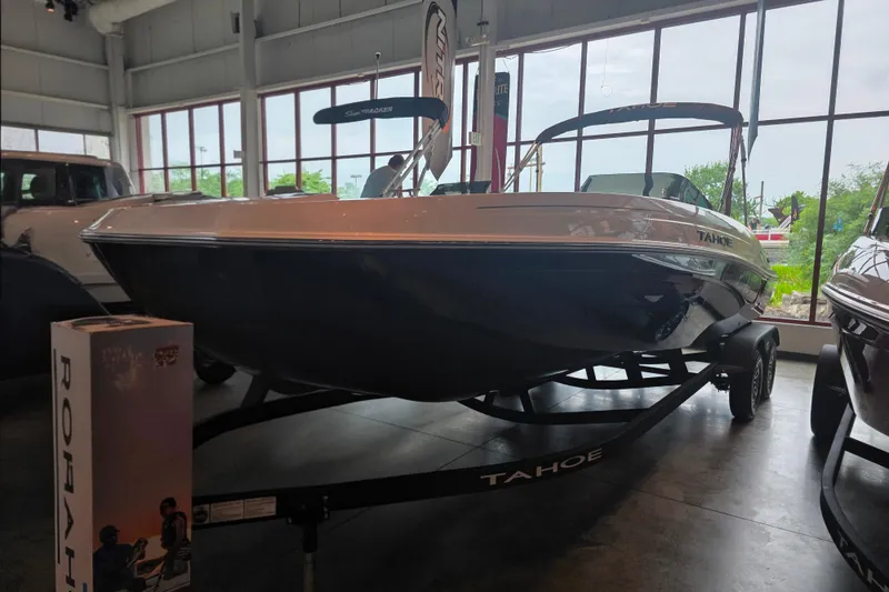Slide: The Image of 2026 Tahoe T21 boat displayed indoors on a trailer. - 91