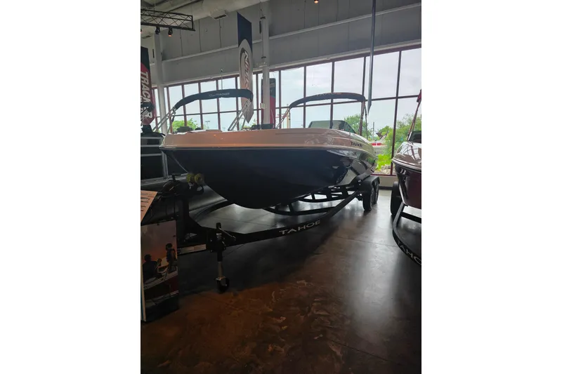 Slide: The Image of 2026 Tahoe T21 boat displayed indoors on a trailer. - 93