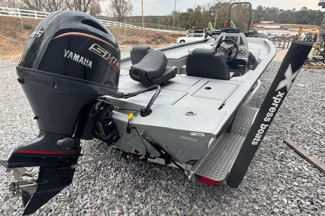 Slide: The Image of 2026 Xpress H18 Bass boat with Yamaha engine, parked on gravel. - 6