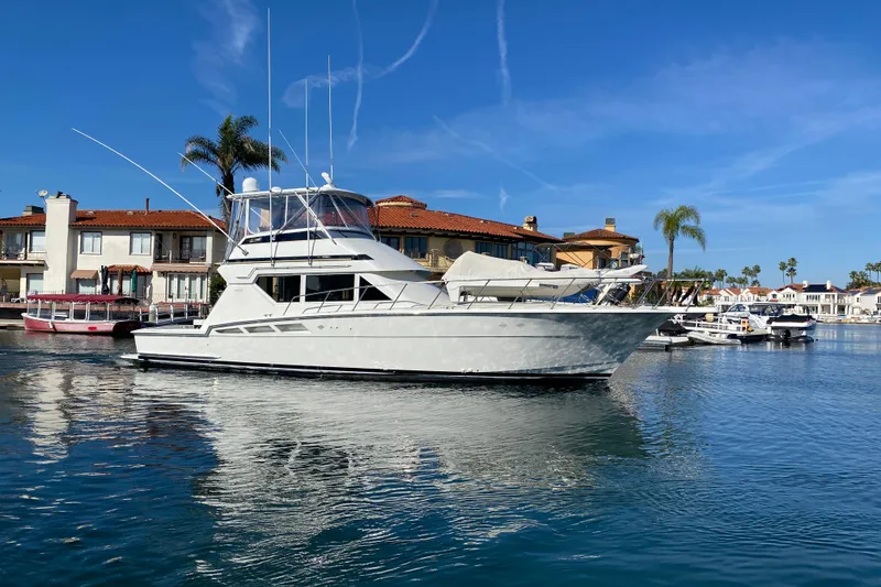 Slide: The Image of 1995 Hatteras 50 Convertible Sportfish yacht docked in a scenic marina. - 13