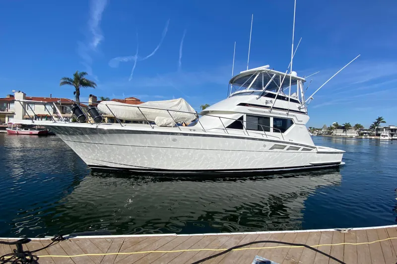 Slide: The Image of 1995 Hatteras 50 Convertible Sportfish yacht docked in sunny marina. - 2