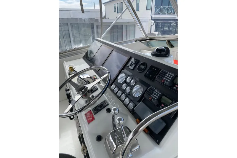 Slide: The Image of 1995 Hatteras 50 Convertible Sportfish helm with steering wheel and control panel. - 35