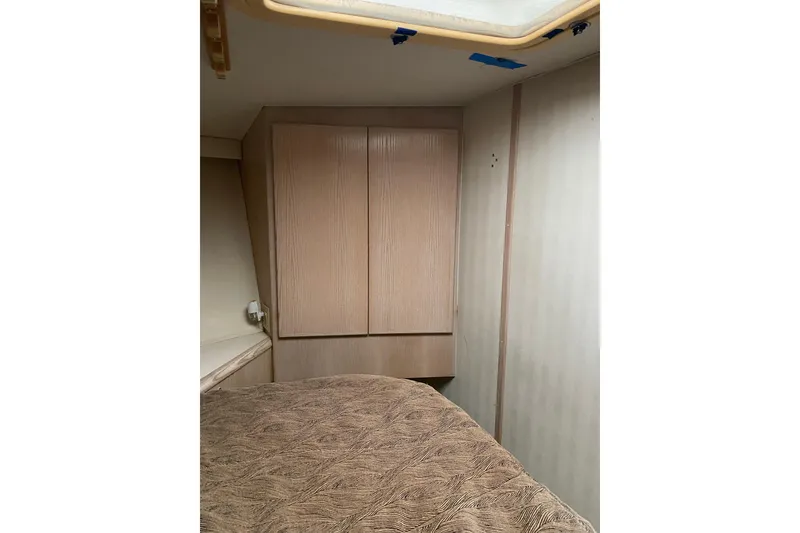 Slide: The Image of Interior cabin of 1995 Hatteras 50 Convertible Sportfish with wood cabinetry and patterned bedding. - 43