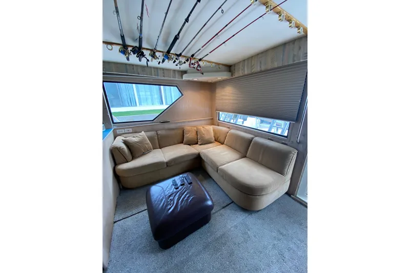 Slide: The Image of Luxurious interior of 1995 Hatteras 50 Convertible Sportfish with cozy seating and fishing rods. - 46