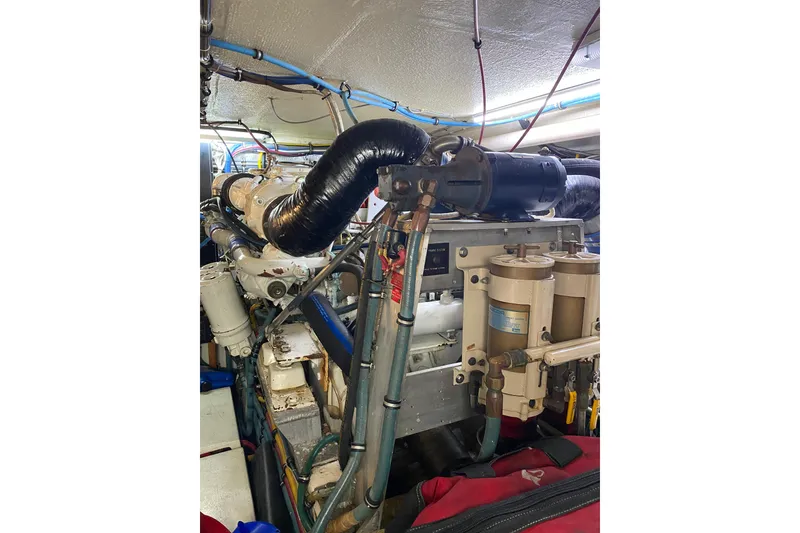 Slide: The Image of Engine room of 1995 Hatteras 50 Convertible Sportfish, showcasing mechanical components and piping. - 66