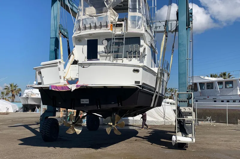 Slide: The Image of 1995 Hatteras 50 Convertible Sportfish yacht in dry dock, showcasing propellers and hull. - 16