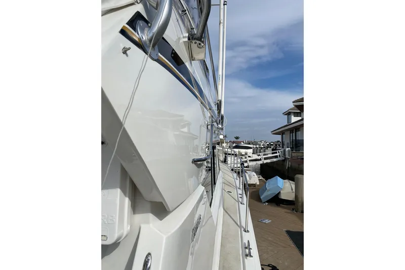 Slide: The Image of 1995 Hatteras 50 Convertible Sportfish yacht docked at marina, side view. - 19