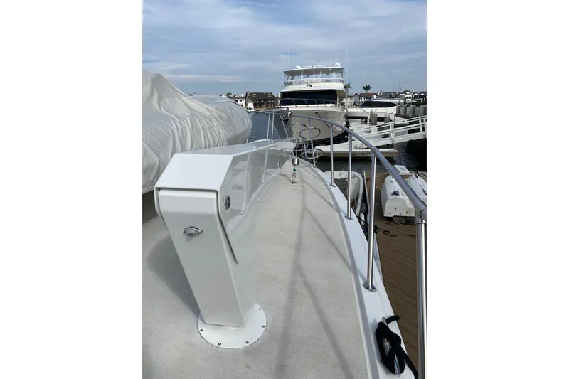 Slide: The Image of 1995 Hatteras 50 Convertible Sportfish yacht docked at marina, showcasing sleek deck design. - 22