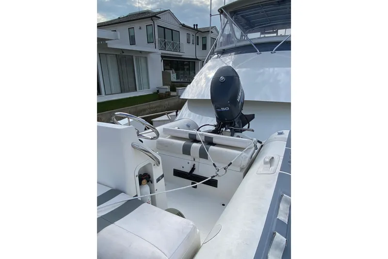 Slide: The Image of 1995 Hatteras 50 Convertible Sportfish boat with Yamaha outboard motor, docked near modern house. - 26